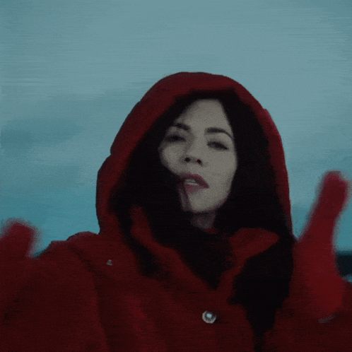 a woman wearing a red coat with a hood on her head
