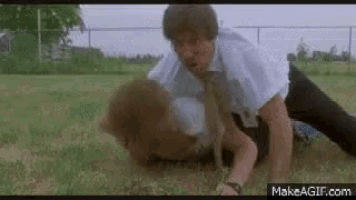 a man is wrestling another man in a field .