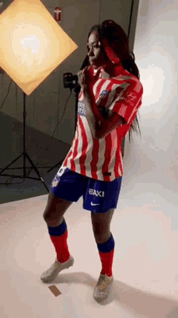 a woman in a red white and blue striped shirt with the number 10 on the shorts