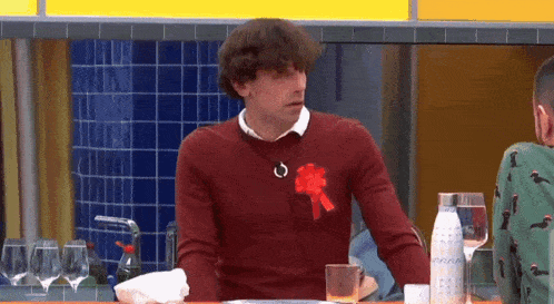 a man wearing a red sweater with a red bow on his chest