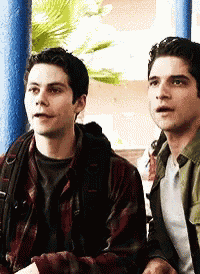 two young men are sitting next to each other and looking at something