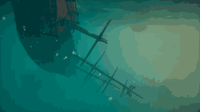 a shipwreck is floating in the ocean with bubbles