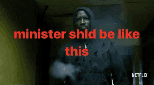 a man in a hooded jacket is standing in a hallway with the words minister shid be like this behind him