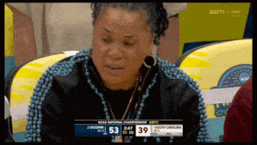 a woman wearing blue beads is crying during a ncaa national championship game between uconn and south carolina