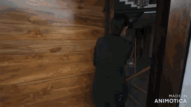 a man in a black suit stands in front of a wooden door made in animatica