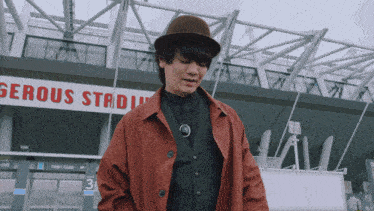 a man in a hat is standing in front of a sign that says serious stadium