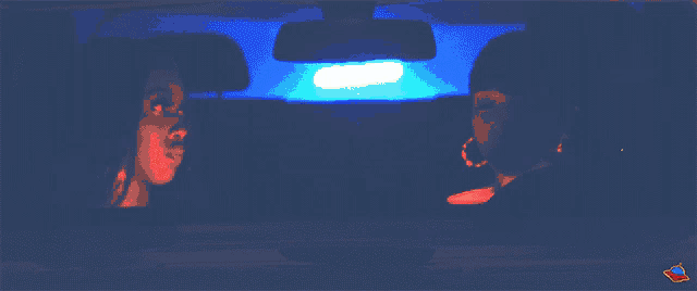 a blurred image of a person in a car with a red rocket in the upper right corner