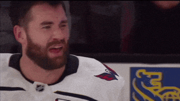 a hockey player with a beard wearing a white jersey with a red eagle on the front