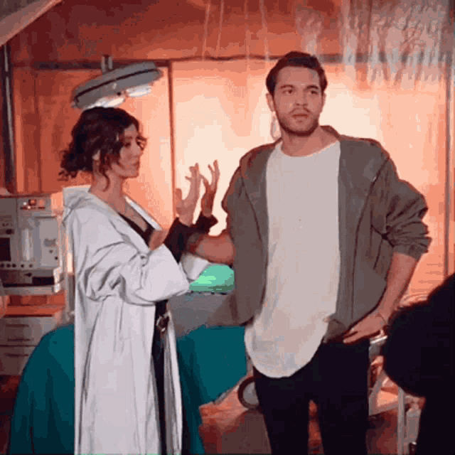 a man and a woman are standing next to each other in a room