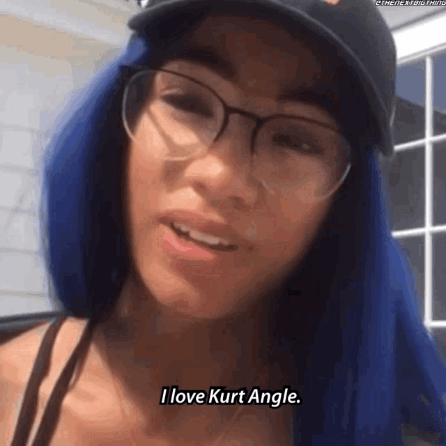 a woman with blue hair is wearing glasses and a hat and says i love kurt angle .