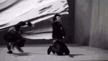 a couple of people are dancing in a room in front of a large screen .