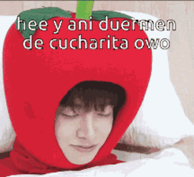 a person wearing a red apple hat with the words hee y ani duermen de cucharita owo