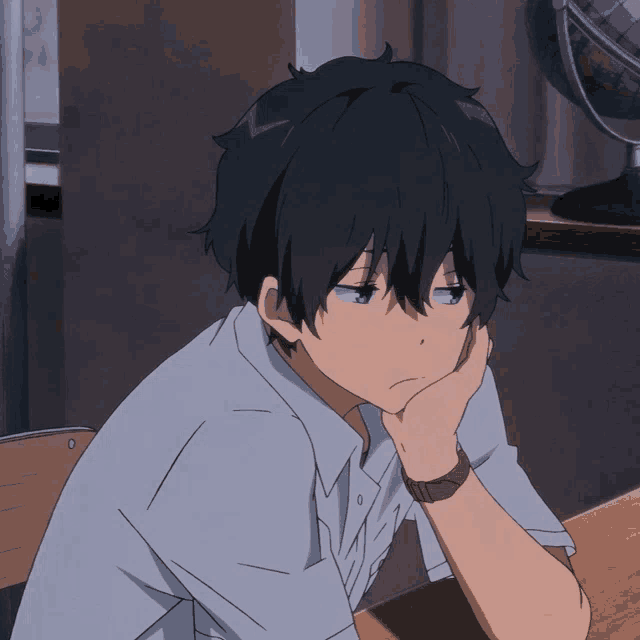 a boy with a watch on his wrist is sitting at a table