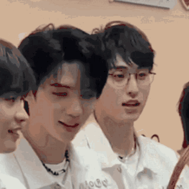 a group of young men wearing white shirts and glasses are standing next to each other