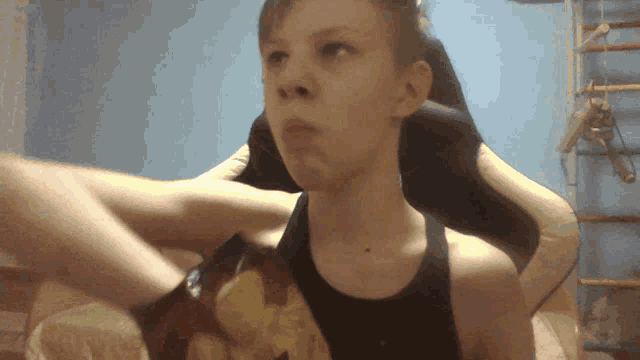 a young boy is sitting in a chair with his arm resting on the back