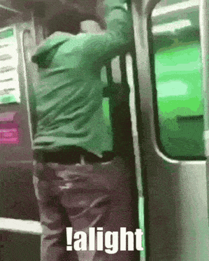 a man in a green jacket is getting on a subway train and says alight .