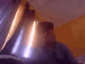 a man is standing in front of a window with a light shining through it