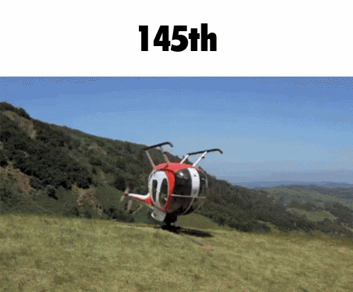 a red and white helicopter is sitting on top of a grassy hill with 145th written on the bottom