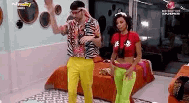 a man and a woman are standing next to each other in a room .