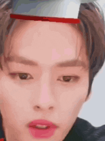 a close up of a young man 's face with a red headband on his head .