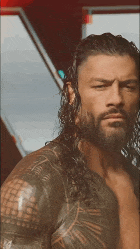 a man with long hair and a tattoo on his arm
