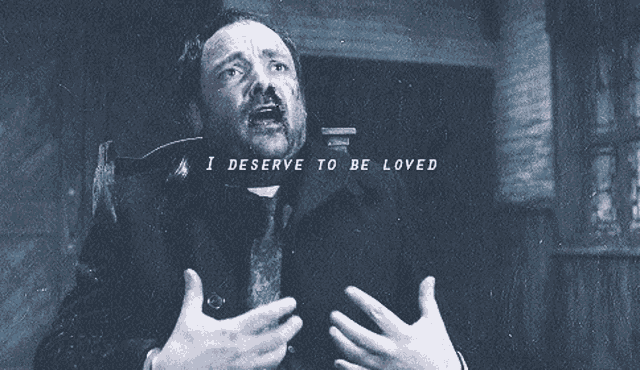 a man in a suit and tie says " i deserve to be loved " with his hands outstretched
