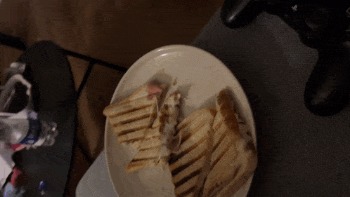 a white plate with a sandwich on it and a coca cola bottle