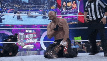 a man in a wrestling ring with a sign that says double nothing in the background