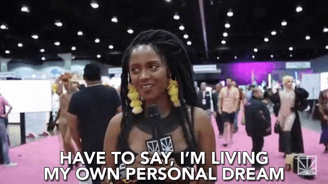 a woman with dreadlocks is talking into a microphone and says have to say i 'm living my own personal dream .