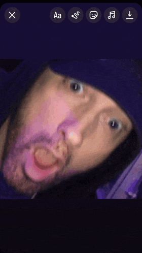 a man in a purple hat is making a funny face with the letters aa visible