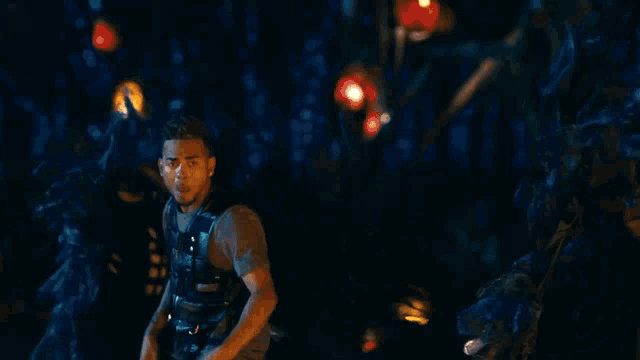 a man is standing in front of a fire at night and screaming