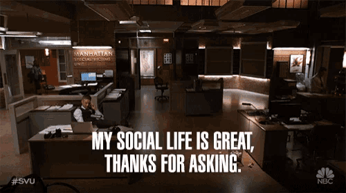 a man sitting at a desk talking on a phone with the words " my social life is great thanks for asking " above him