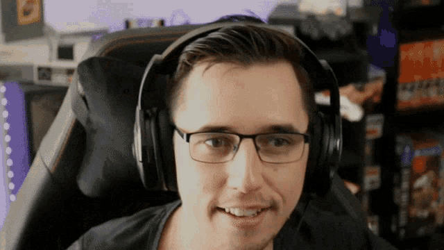 a man wearing glasses and headphones is smiling for the camera