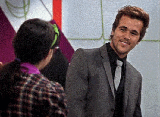 a man in a suit and tie smiles at a girl