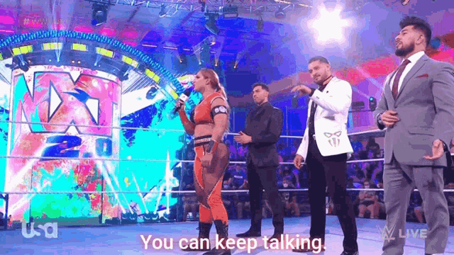 a man in a suit says " you can keep talking " to a woman in a wrestling ring