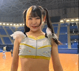 a girl with pigtails and a crop top is standing in a stadium