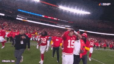 a football player with the number 15 on his jersey is being escorted off the field