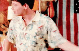 a man in a hawaiian shirt is standing in front of an american flag