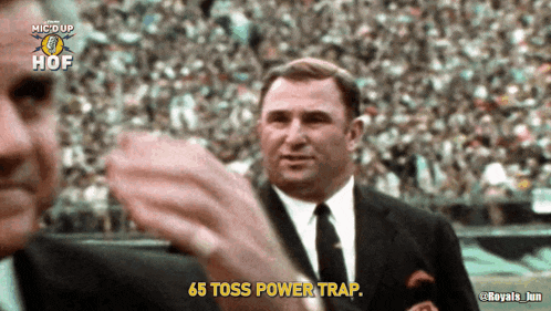 a man in a suit and tie is saying " 65 toss power trap "