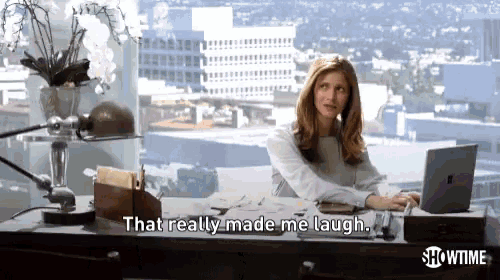 a woman sits at a desk in front of a laptop and says " that really made me laugh "