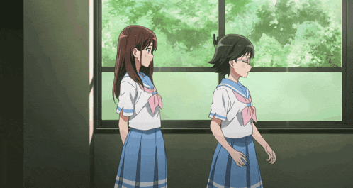 two girls in school uniforms are standing in front of a window