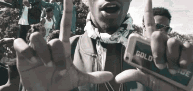 a man is holding a cell phone with the word gold on it