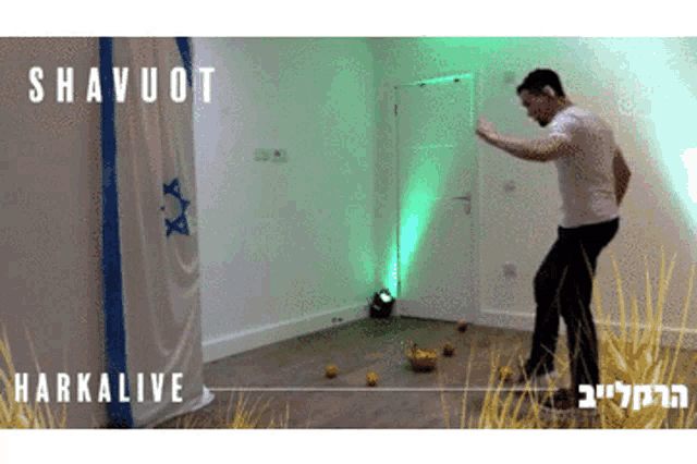 a man is dancing in front of a banner that says ' shavuot ' and ' harkalive '