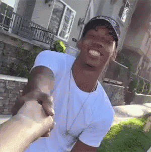 a man in a white shirt is shaking hands with another man .