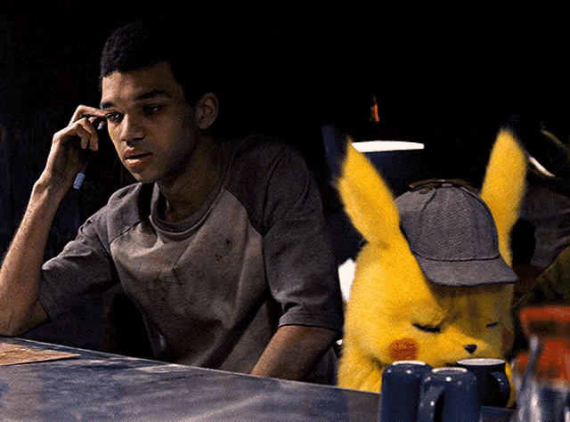 a man talking on a phone next to a pikachu