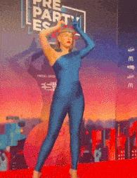 a woman in a blue jumpsuit is standing in front of a pre party sign