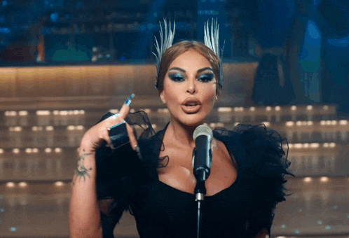 a woman singing into a microphone wearing a crown
