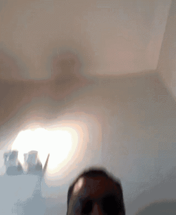 a blurry photo of a man 's face with a light shining through the window