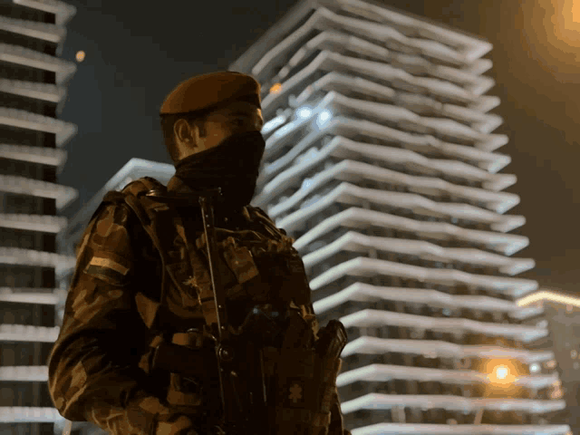a soldier stands in front of a building at night