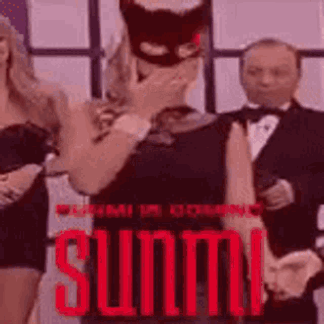 a woman wearing a cat mask is covering her mouth in front of a man in a tuxedo